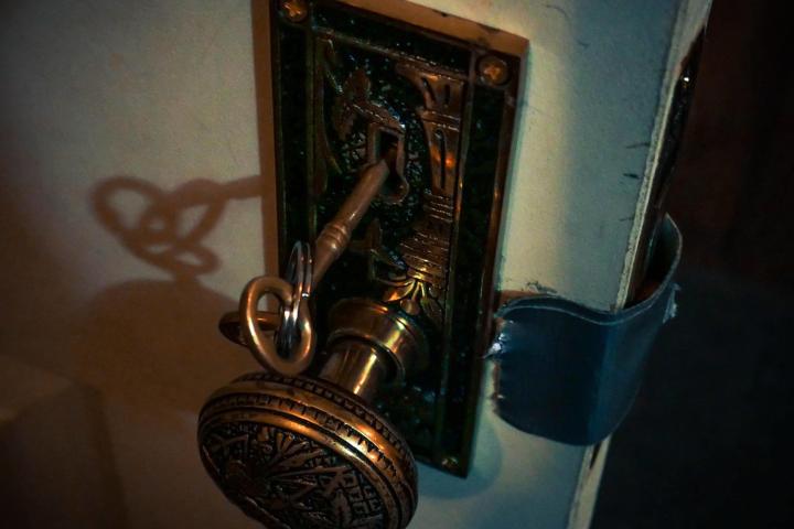 Door Knob with Key on White Wooden Door